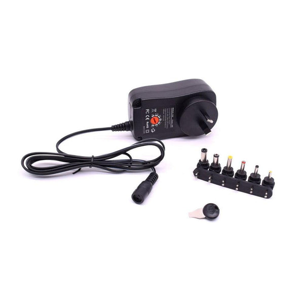 Black AC power adapter with various interchangeable DC tips and a small key.
